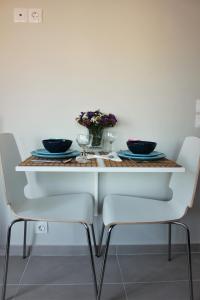 uma mesa branca com duas tigelas pretas e flores em Xenon Loft em Atenas