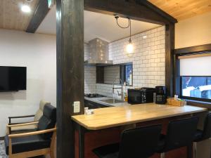 a kitchen with a wooden counter in a room at Ryder's House with Free use of 4W car in Hakuba