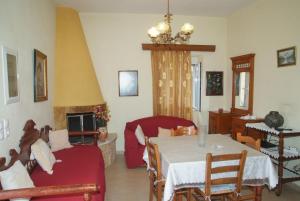 a living room with a table and a red couch at Tourloti Village House in Tourlotí