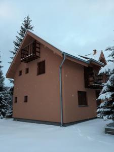 un bâtiment avec de la neige devant lui dans l'établissement Apartmani Nikolic, à Kopaonik