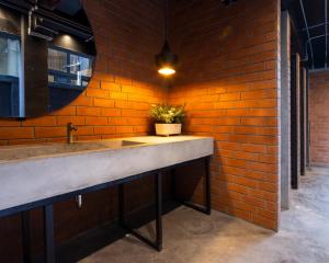 曼谷BED STATION Hostel Khaosan的带水槽和砖墙的浴室