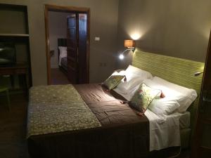 una camera da letto con un grande letto con cuscini bianchi di La Rocca Guest House & Spa a Montefalco