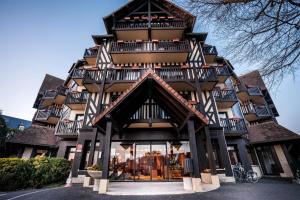 トゥルヴィル・シュル・メールにあるBest Western Plus Hostellerie Du Vallonのバルコニー付きの大きな建物