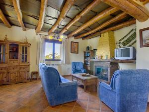salon z niebieskimi krzesłami i kominkiem w obiekcie Alpujarra Cortijo Casilla Noguera w mieście Pórtugos