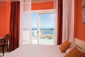 a hotel room with a bed and a window at Lu' Hotel Riviera in Carloforte