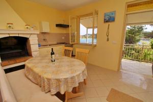 a kitchen and dining room with a table and a fireplace at Apartments Villa Steffi in Prizba