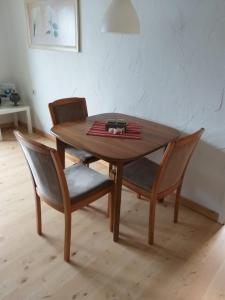 a wooden table with two chairs and a table and a table at Ferienwohnung mit Herz in Nauort