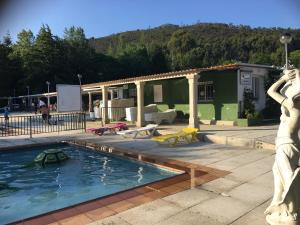 a swimming pool with a statue in front of a building at Camping Rural Ria de Arosa 2 in Ribeira