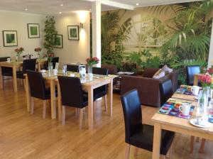 a dining room with tables and chairs and plants at The old post office in Bicester