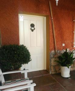 a white door in a room with two potted plants at Paz Rural a una hora de Madrid in Hontoba