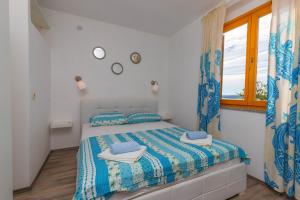 - une chambre avec un lit et une fenêtre dans l'établissement Apartments Maris, à Crikvenica