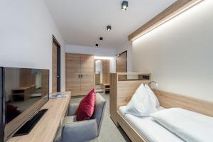 ein Schlafzimmer mit einem Bett, einem Sofa und einem Schreibtisch in der Unterkunft Frühstückspension Broser in Obergurgl