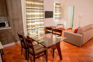 une salle à manger avec une table et des chaises en verre dans l'établissement Dimora De Mauro, à Catane