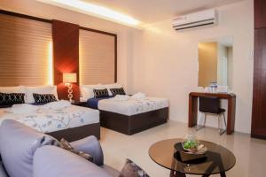 ein Hotelzimmer mit 2 Betten, einem Sofa und einem Tisch in der Unterkunft Mezza Hotel in Koronadal
