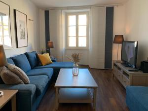 a living room with a blue couch and a table at Apartment Marciana in Piran
