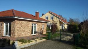 a brick house with a gate in front of it at Villa Belair Schmidt in Dorum-Neufeld