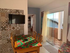 ein Esszimmer mit einem Tisch und einem TV in der Unterkunft Residencial Marcelo e Irene in Florianópolis