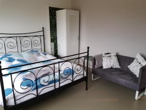 een slaapkamer met een bed en een bank bij B&B Manege Groenewoude in Woudenberg