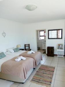 a bedroom with two beds and a rug at Kairos Cottage B&B in Lüderitz
