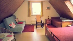 Cette chambre mansardée comprend un lit et un canapé. dans l'établissement Sommerferienhaus, à Nienhagen