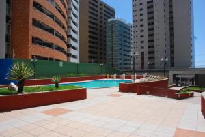 a swimming pool in a city with tall buildings at Porto de Iracema - Iracema Imoveis in Fortaleza