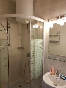 uma casa de banho com um chuveiro e um lavatório. em Hostel Residence em Sarajevo