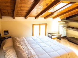 Un dormitorio con una cama grande en una habitación con techos de madera. en Le Finestre Su Borghetto en Valeggio sul Mincio