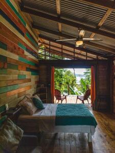 1 dormitorio con 1 cama y pared de madera en Surf Break at Paunch, en Bocas Town
