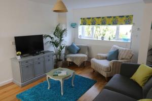 uma sala de estar com um sofá e uma televisão em 4a Dolphin Close em Lyme Regis