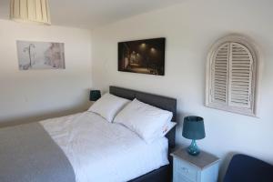 um quarto com uma cama branca e uma janela em 4a Dolphin Close em Lyme Regis