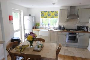 una cocina con una mesa con un jarrón de flores. en 4a Dolphin Close, en Lyme Regis