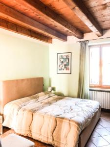 a bedroom with a large bed with wooden ceilings at Le Finestre Su Borghetto in Valeggio sul Mincio