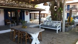 une table et un banc sur une terrasse dans l'établissement Pousada Maria Farinha, à Búzios