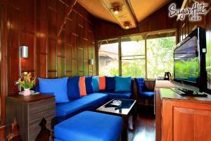 a living room with a blue couch and a tv at Sugar Hut Resort & Restaurant in Pattaya South