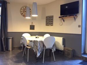 comedor con mesa y sillas blancas en Le Gite des Tourelles en Bèze