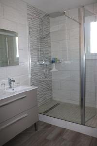 W łazience znajduje się prysznic z umywalką i przeszkloną kabiną prysznicową. w obiekcie B&B L'Oustalet de Sylvie w mieście Villeneuve-lès-Avignon