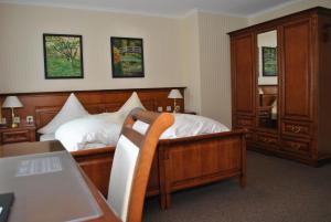a bedroom with a bed and a dresser and a table at Waldhotel Rheinbach in Rheinbach +45 photos