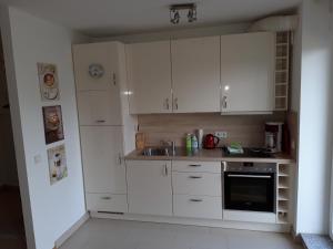 a kitchen with white cabinets and a sink at Quellenresidenz Bad Vilbel in Bad Vilbel
