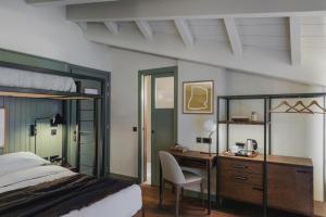 a bedroom with a bed and a desk and a bed and a chair at Albergo Miramonti in Corteno Golgi