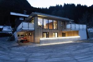 een groot huis met veel glazen ramen bij Haus Galgenul in Sankt Gallenkirch