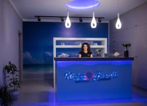 a woman standing behind a counter in a room with a blue wall at Kastro Beach Apartments in Malia +57 photos