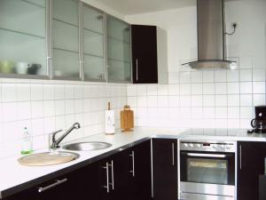 a kitchen with a sink and a stove at Gästehaus UP-Arnold in Pinneberg