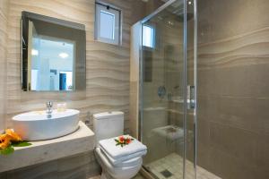 a bathroom with a toilet and a sink and a shower at Kastro Beach Apartments in Malia
