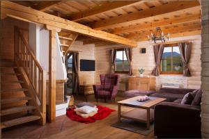 a living room with a couch and a staircase in a cabin at Víkendové Chalupy in Liptovský Trnovec
