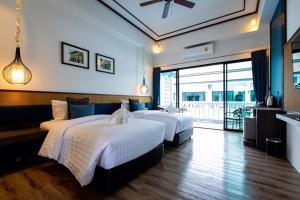 een hotelkamer met twee bedden en een balkon bij Chaanburi Boutique Resort in Chanthaburi