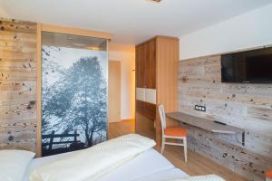 a bedroom with a bed and a desk and a television at Apartment Alpenperle in Schladming
