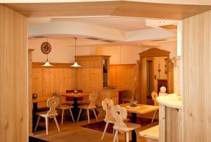 a kitchen with chairs and a table and a dining room at Hotel Waldheim in Valle Di Casies