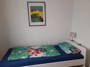 ein Bett in einem Schlafzimmer mit einem Bild an der Wand in der Unterkunft Ferienhaus Maiglöckchen in Papenburg