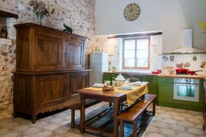 cocina con mesa de madera y armarios verdes en Gite de la Petite Burnie, en Biras