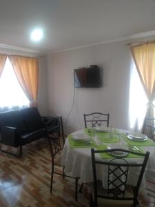 a living room with a table and chairs and a couch at Departamento Familiar in Coquimbo